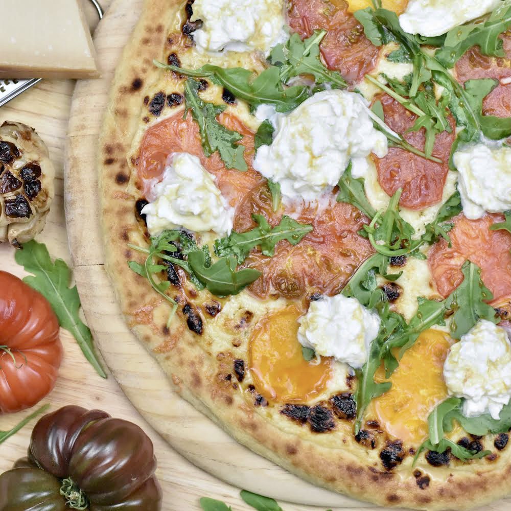 White Garlic Pizza with Heirloom Tomatoes Burrata and Arugula with a Fermented Garlic Sweet Sorghum